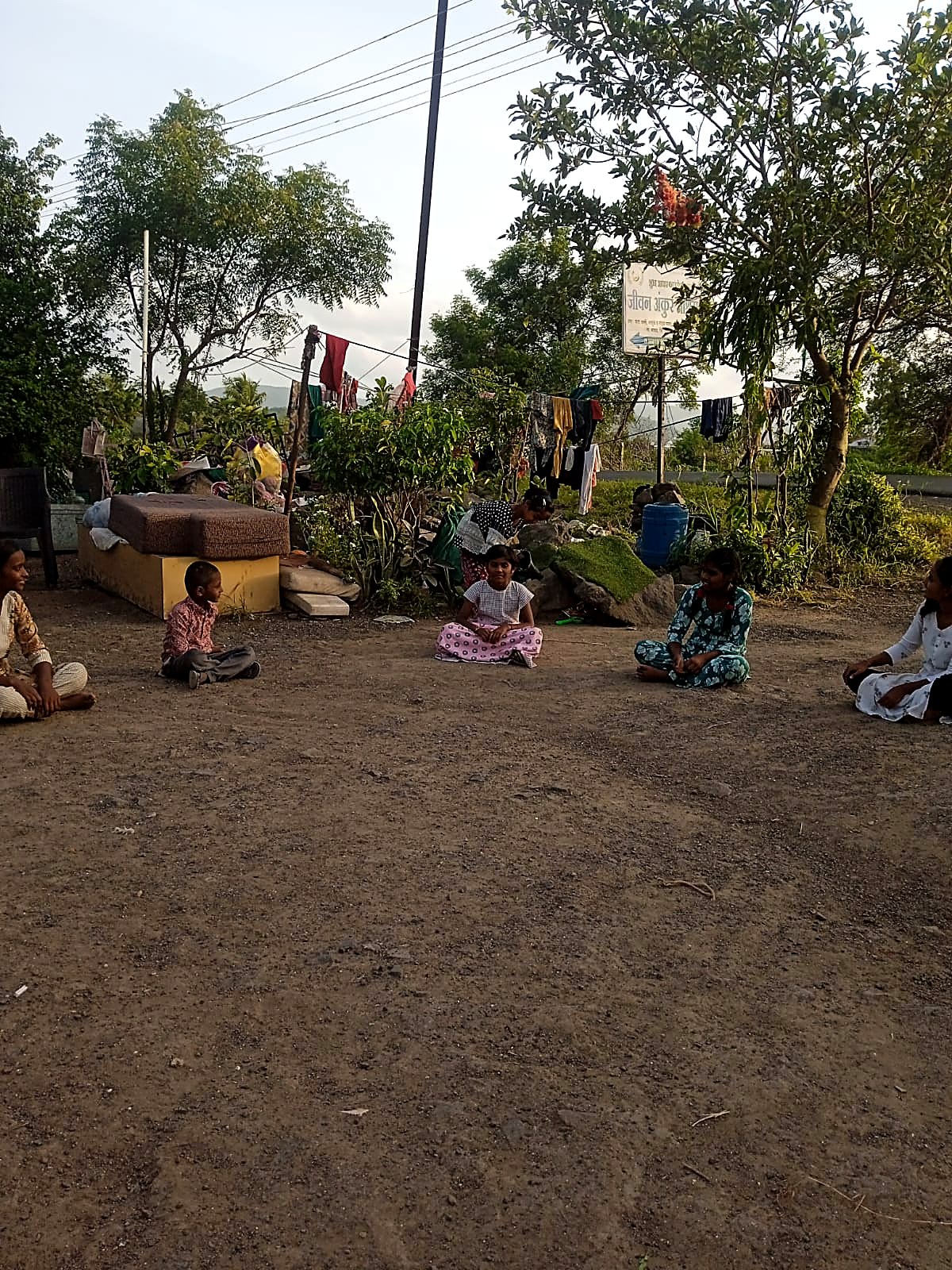 संध्याकाळी आश्रमाच्या अंगणात बसलेली मुले