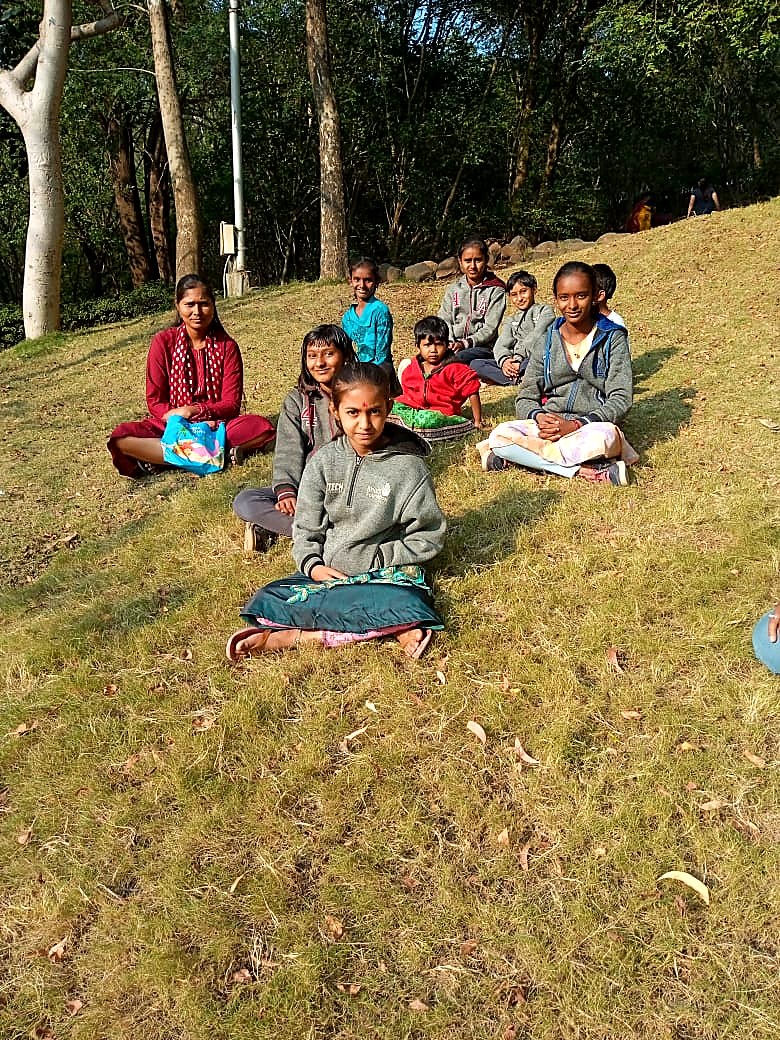 बागेतल्या हिरवळीवर बसलेली मुले